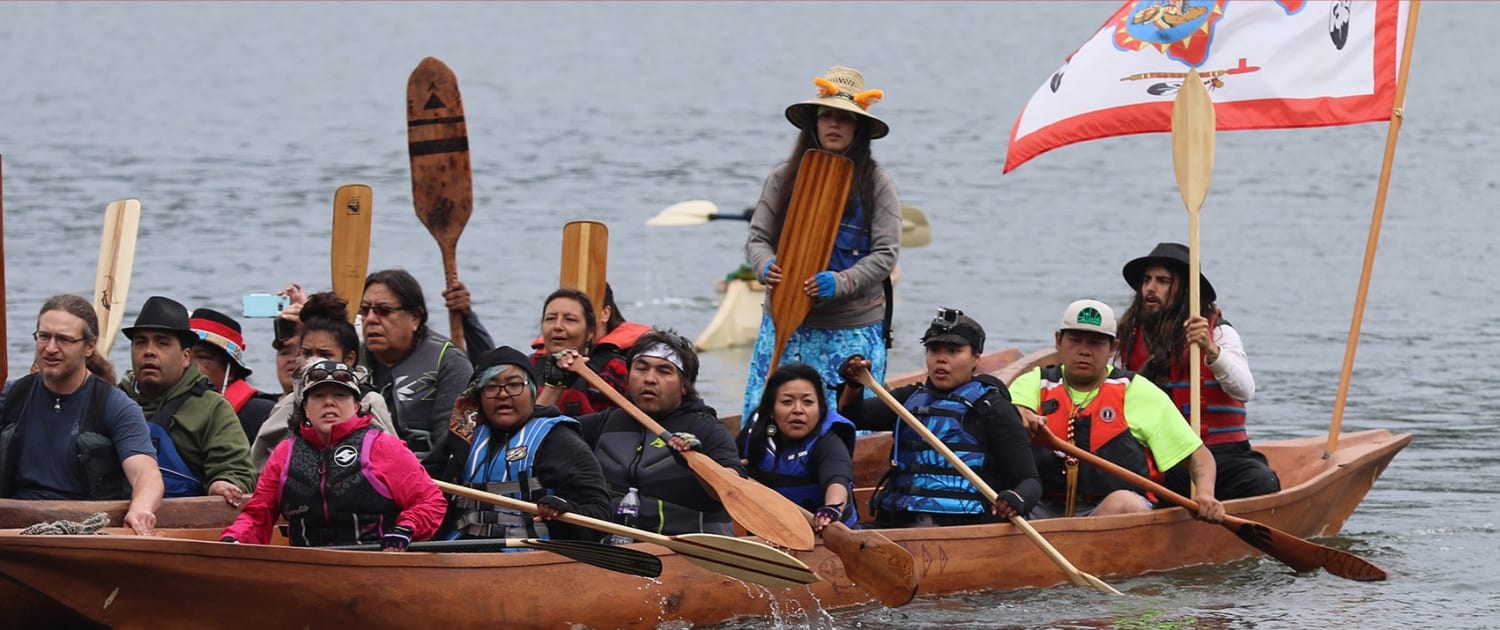 People in boats crossing a body of water